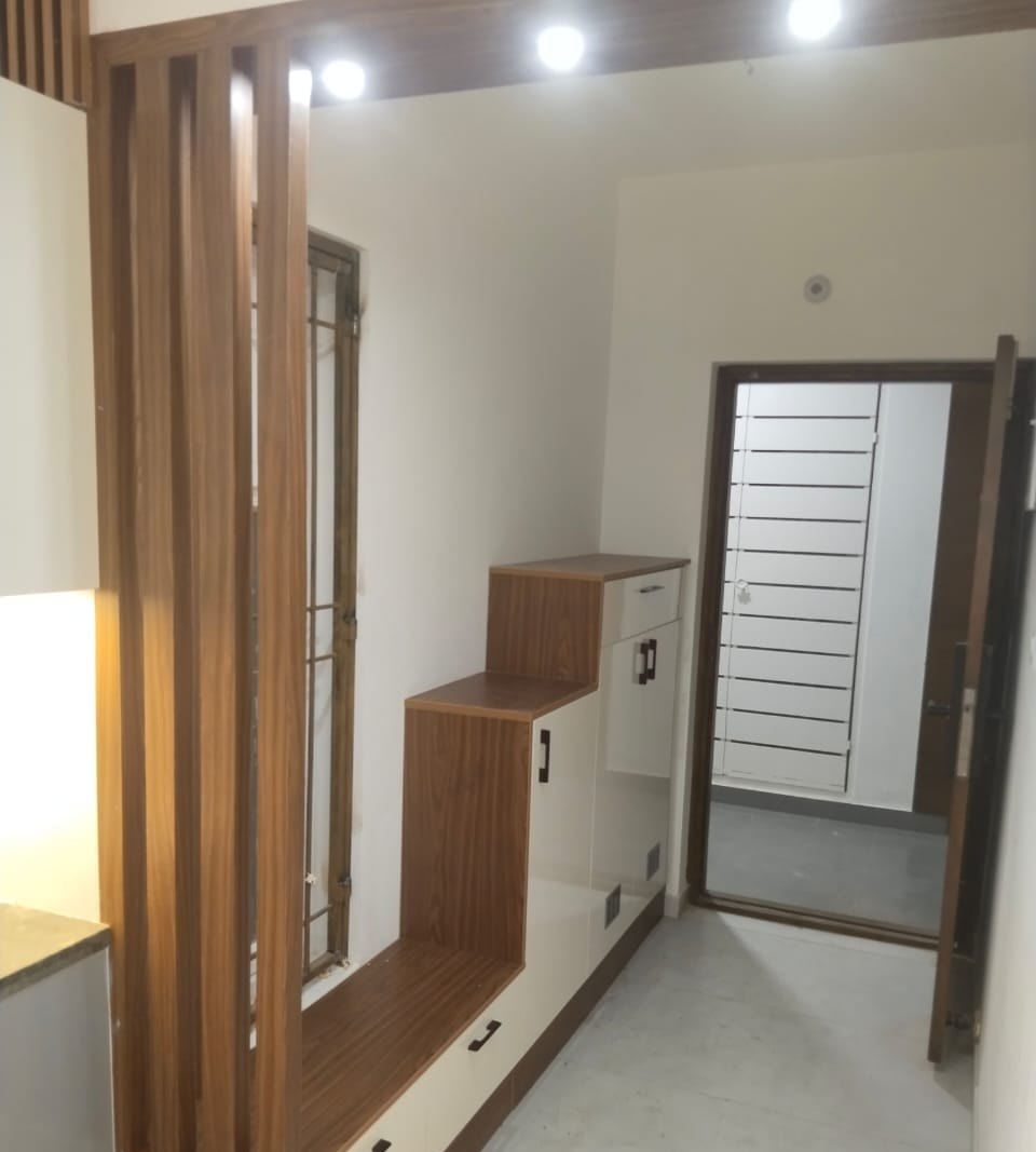 Foyer with a slatted timber partition and fitted shoe storage, by Padmodya Interiors