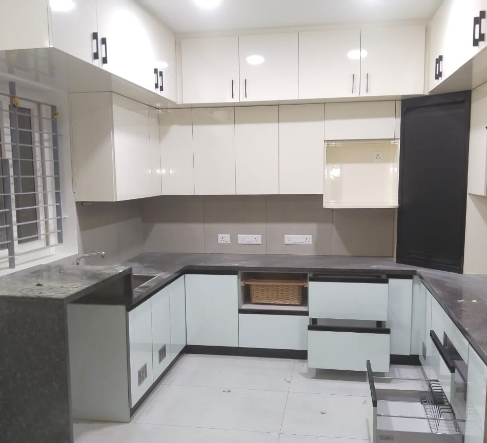 U-shaped modular kitchen in white and grey with a stone counter, by Padmodya Interiors