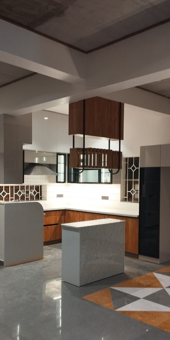 Kitchen with island and breakfast counter, by Padmodya Interiors