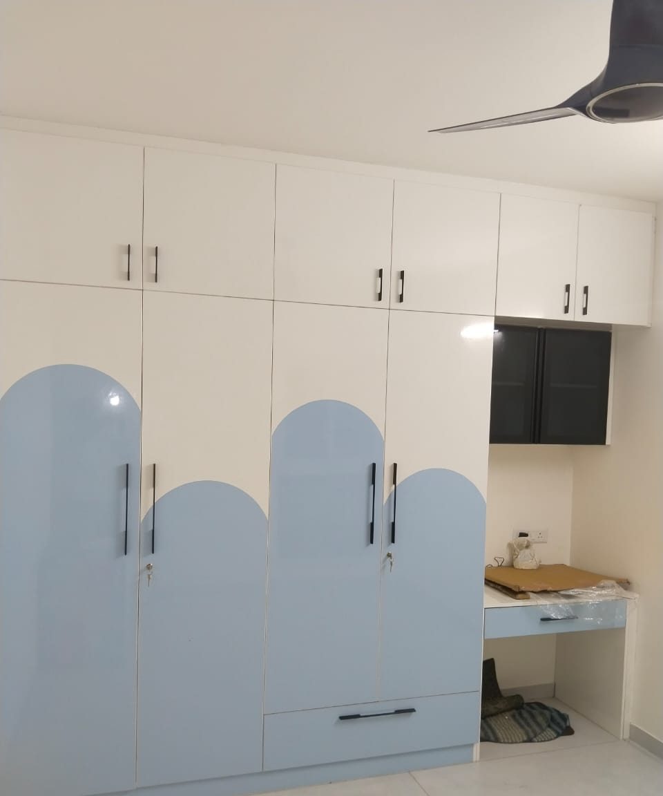 Arched wardrobe with study desk, by Padmodya Interiors